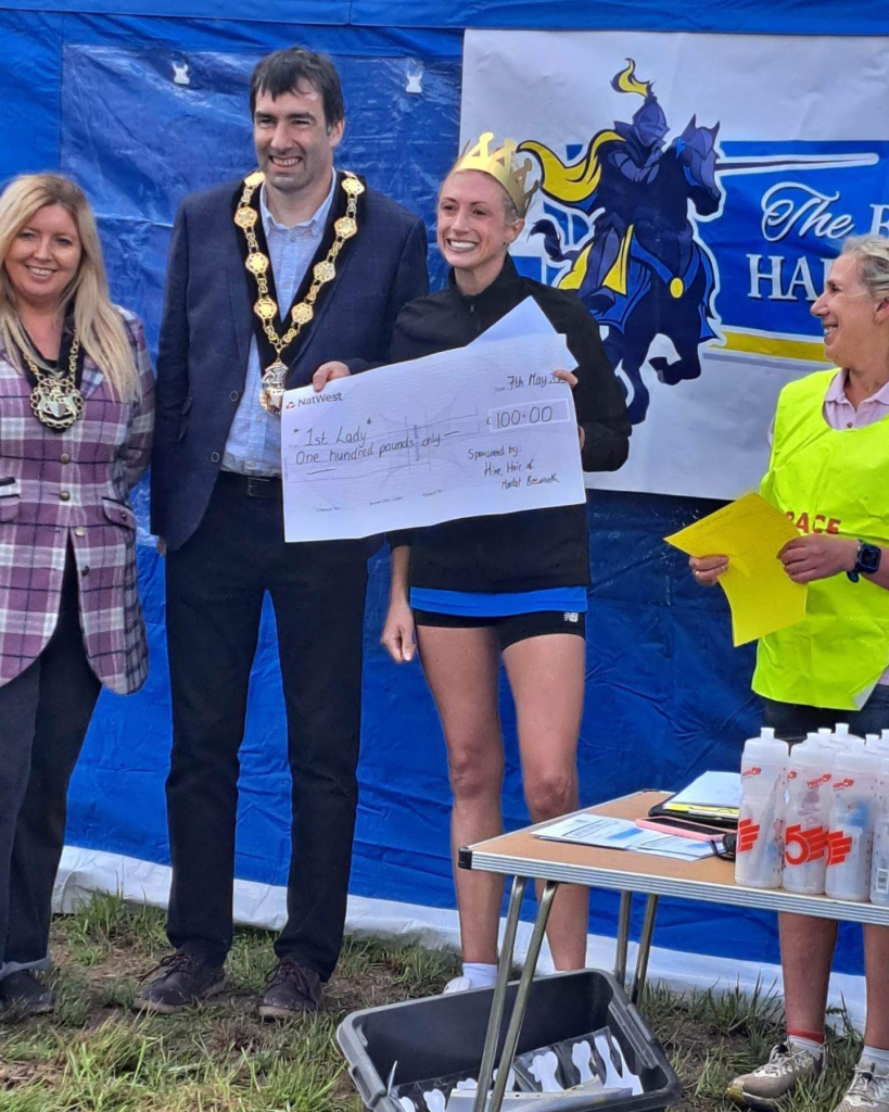 Rebecca collecting her cheque for £100 for coming in first lady in the Bosworth Half Marathon